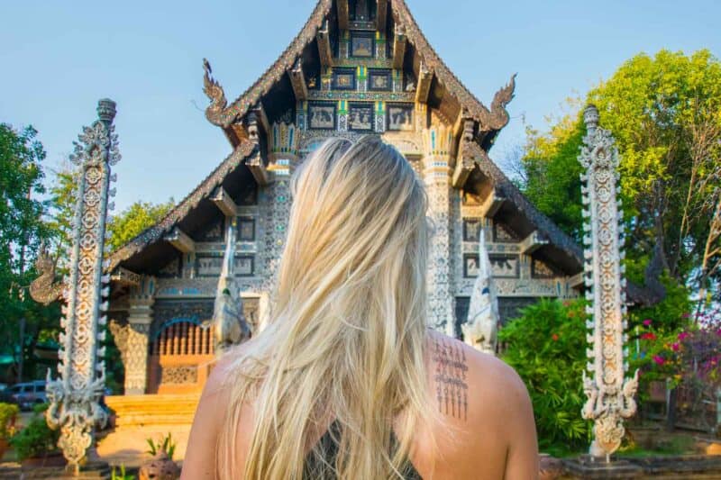 Hannah de pie frente a un templo en Chiang Mai con su nuevo tatuaje Sak Yant