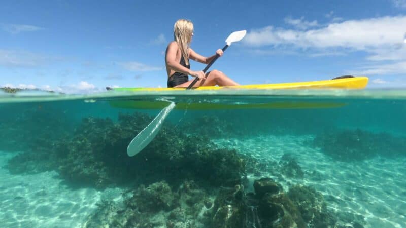 woman paddling a kayak in the Cook Islands - GoPro Filming Tips