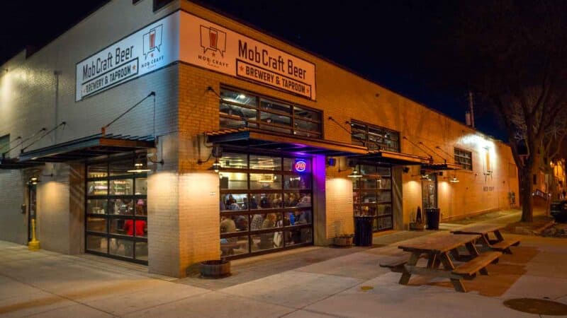 MobCraft Beer Brewery and Taproom at night with large garage doors and Patio - Top craft breweries in Milwaukee