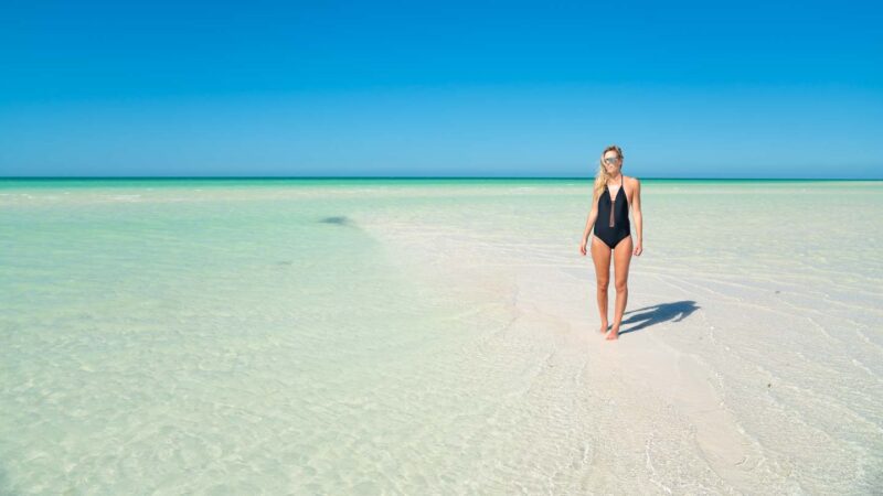 Woman standing on a sandbank on Isla Holbox Mexico - Places to visit