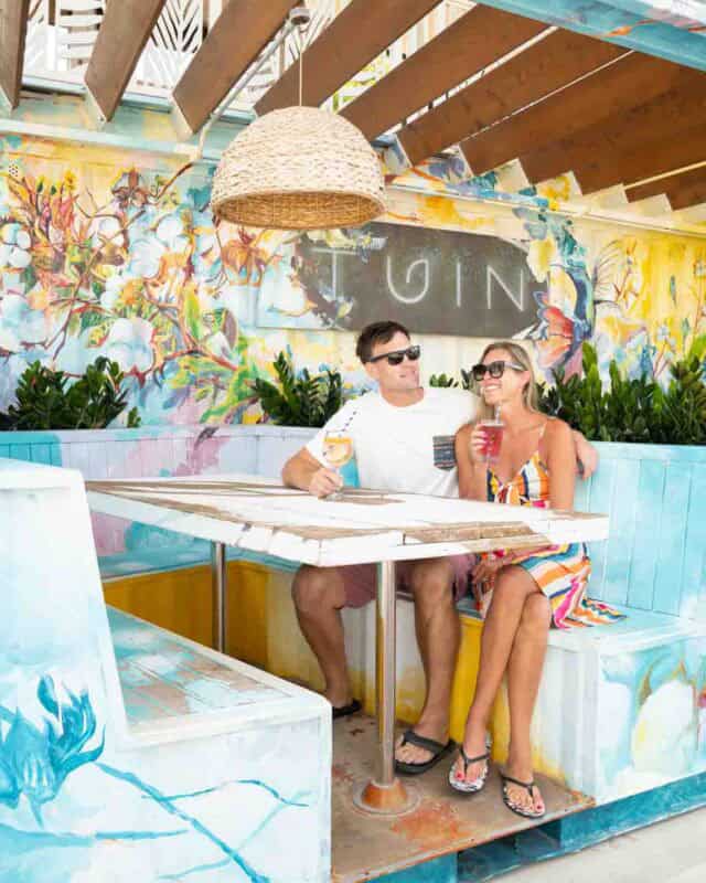 Couple in a bench at one of the many bars at Sandals Curacao drinking a drink