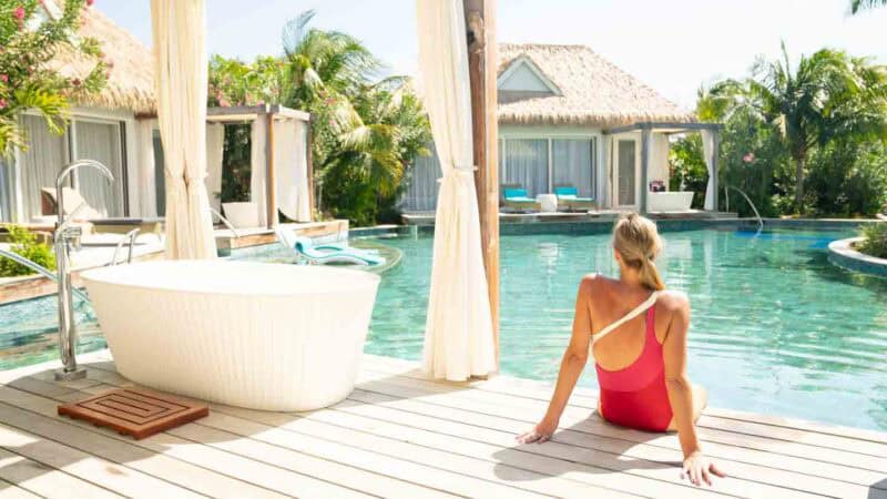 Woman sitting on the deck of a Kurason Island Suite  at Sandals Royal Curacao Resort