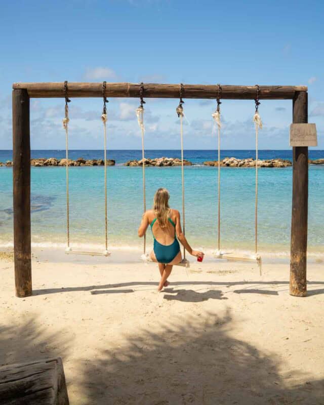 woman on swings at Mambo beach in Curacao 