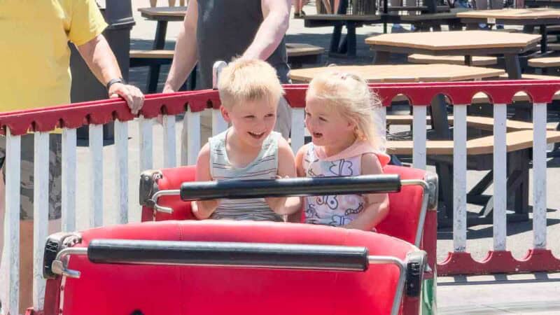 two toddlers riding a ride at a theme park